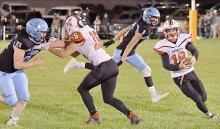 Senior Caleb Allen (#18) carried the ball 16 times for 116 yards against Summerland. Senior Cash Reynolds (#16) blocks for Allen in their final game in an Ainsworth uniform.