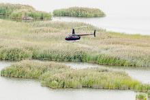 A contractor hired by Nebraska Game and Parks uses a helicopter to apply herbicide to phragmites, an invasive, noxious weed, at Niobrara Confluence Wildlife Management Area on the Missouri River near the Village of Niobrara. Eric Fowler, NEBRASKAland Magazine/Nebraska Game and Parks Commission