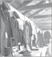 Several armed forces uniforms hung on display in the antiques division exhibit building.