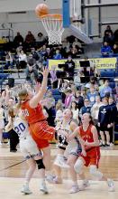 Vying for rebound position, Ainsworth and West Holt players watch the ball teeter on the rim. The Ainsworth shot finally dropped in to two-points.