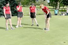 The Ainsworth Girls Golf Team works together to sink a bogey putt on hole 9.