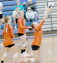 Teammates Gracyn Painter (22) and Cheyan Temple (14) watch as Karli Kral (11) goes to her knees to save the ball from hitting the floor and send it back to the Lady Eagles.