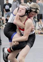 Mason Painter strains for a lift and take down at the Class D-1 District wrestling competition.