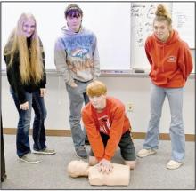 These AHS freshmen, (Standing Left to Right) Addah Booth, Tailor Turpin and Kaitlyn Sease, along with Sam Titus (Kneeling) are learning CPR on a mannequin.