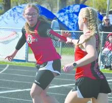 Gracyn Painter (left) and Kiley Orton (right) make a handoff during the 4x400 meter relay last season.