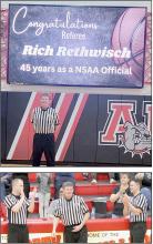 Rethwisch's fellow referees congratulate him during the recognition at the Ainsworth/McCook basketball game.
