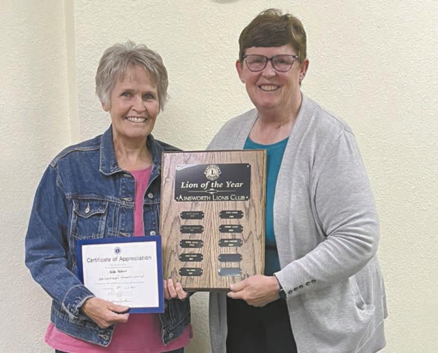 Connie Lentz (right) presents Rita Paddock (left) with the Lion of the Year plaque and certificate.