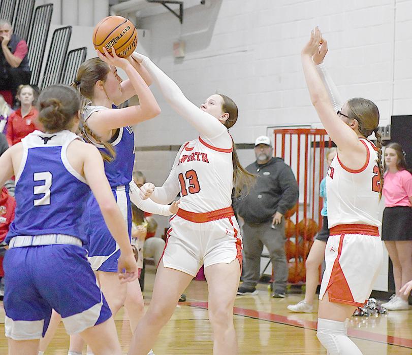 Sophomores Puridy Haley and Gracyn Painter play defense as a Lady Longhorn attempts a shot in the paint.