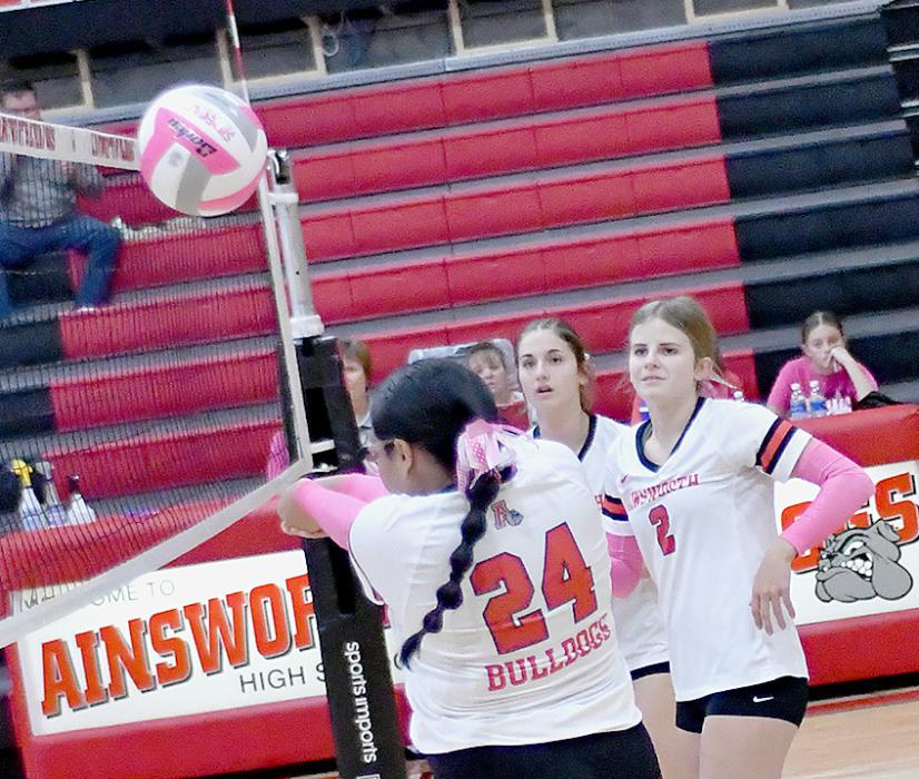 Sophomore Genessis Agin (24) hits the ball towards the net while Jaylee Good (2) and Willa Flynn are ready to assist her.