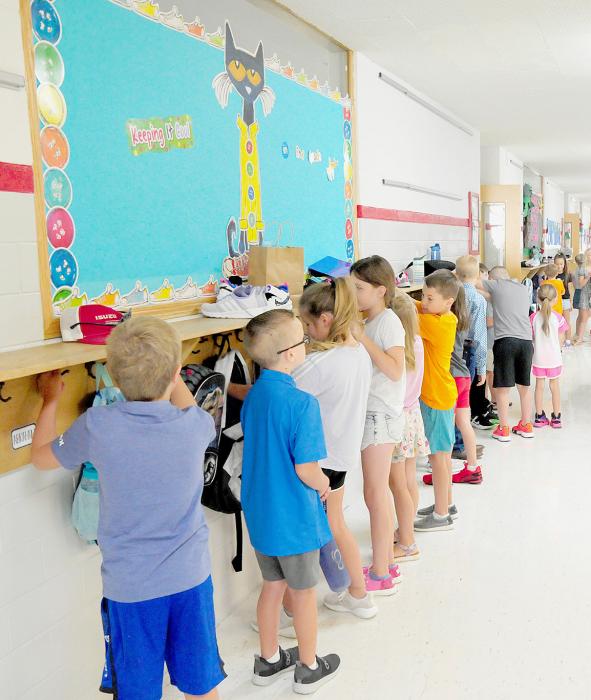 In the hallway by each classroom, students were locating their name on the wall where they will place their backpacks and coats when they aren’t using them.