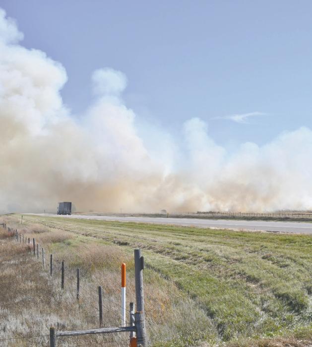 A truck drives through a wall of heavy smoke from the harvest fire on Thursday. The fire was just south of Highway 20 west of Ainsworth.