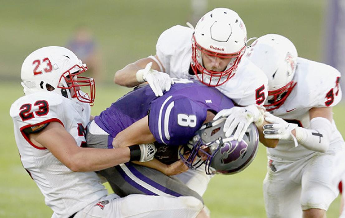 Cole Swanson - #23, Owen Blumenstock - #5 and Aiden Jackman - #33 combine to stop Hartington-Newcastle’s quarterback Cole Heimes.