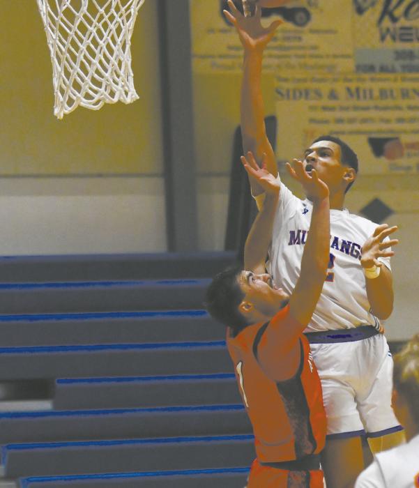 Chris Fernandez (left) plays defense as the Mustangs Braylon Holston attempts a layup.