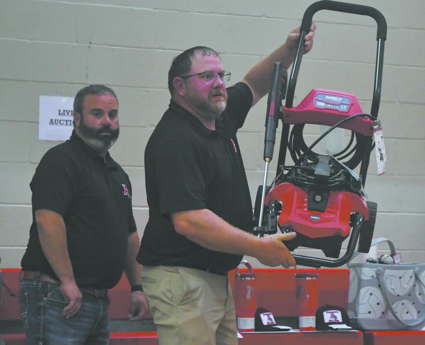 Several businesses donated items for the auction during the event. Troy Brodbeck displays a power washer donated by Mitchell Equipment.