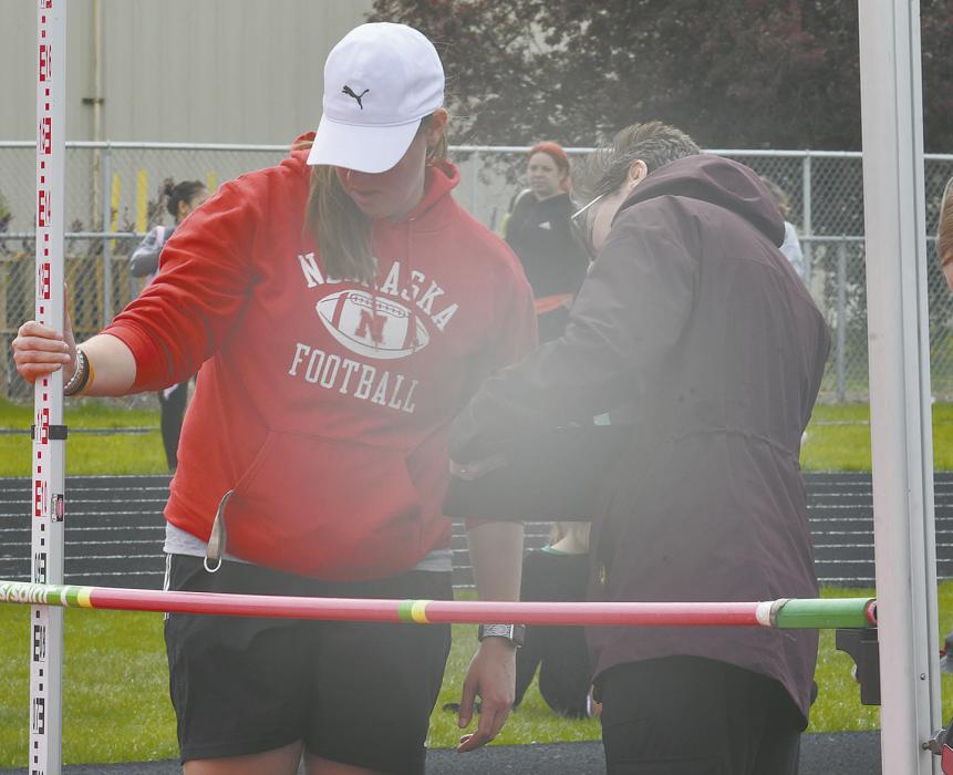 Ainsworth Middle School teachers Heather Lutter (left) and Nichole Flynn (right) set the bar up during sixth grade high jump.