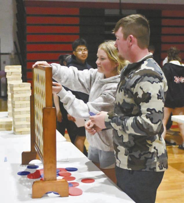 Prom King Witten Painter and his date, Kenley Welke, play Connect 4 during post prom.