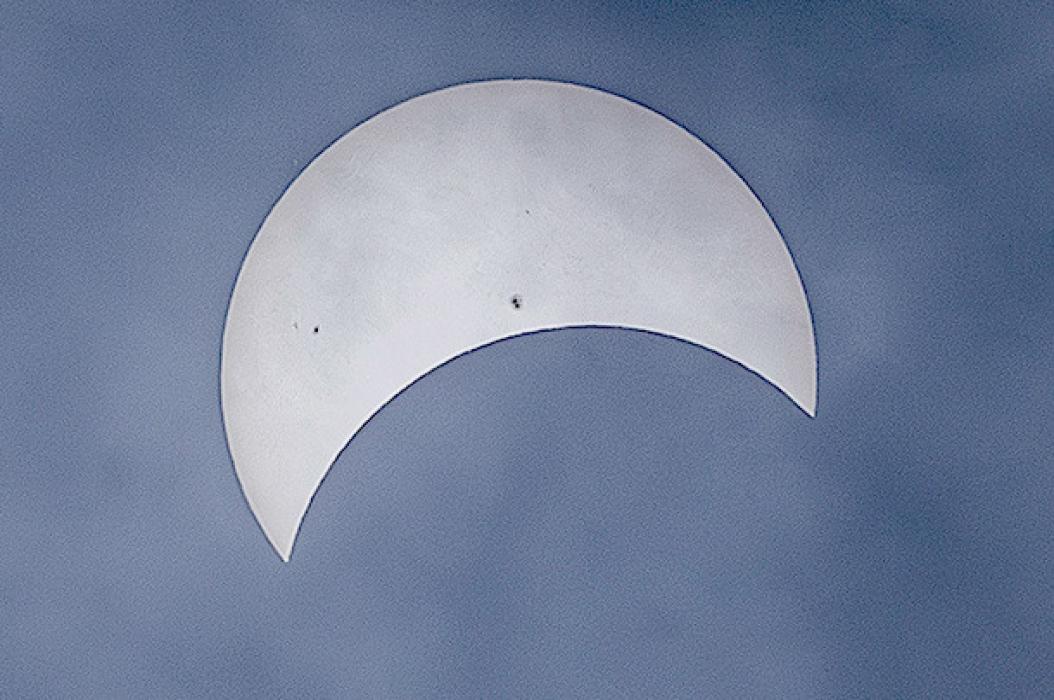 Cloudy skies made photographing the eclipse challenging, but viewing among the swirling clouds was riveting! Notice the sun spots visible - reserved for cloudy, or smoky skies, but always there. Photo by Laura Vroman