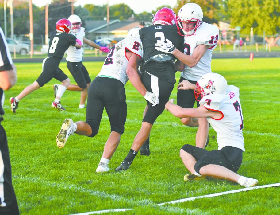 Three Bulldogs, Zaine Evans (2), Graham Duester (13), and Ben Clingman (7), work to take down O'Neill St. Mary's Ben Barlow (3).