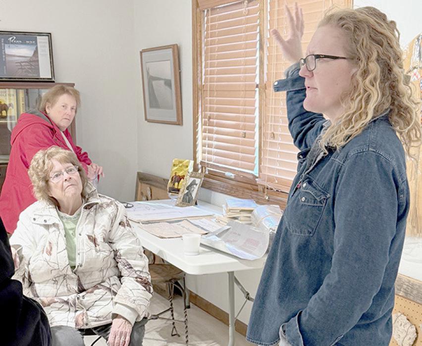 Amy Meyer, Audubon of Kansas director, explains background of the Hutton Ranch Museum to Audrey Wilson and Carol Woods and other Ainsworth Art Guild members.