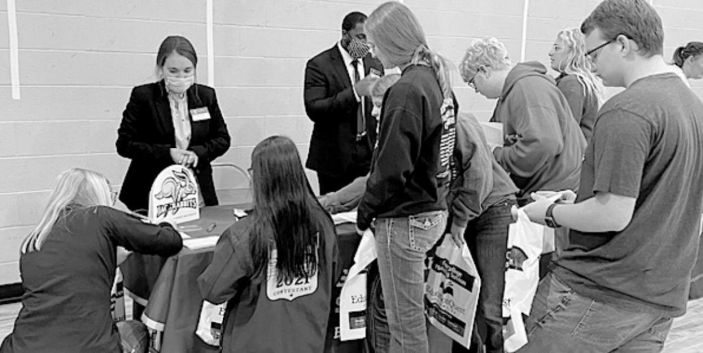 Several students write down information while listening to the representative from South Dakota State University.