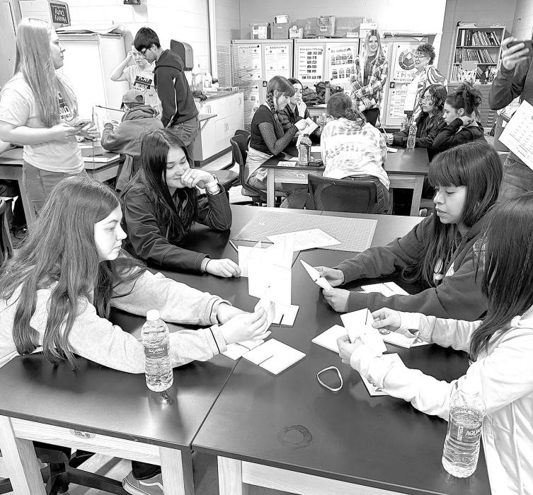 Ciara Brede and Angeles Sedeno collaborating with other students to create a sculpture.