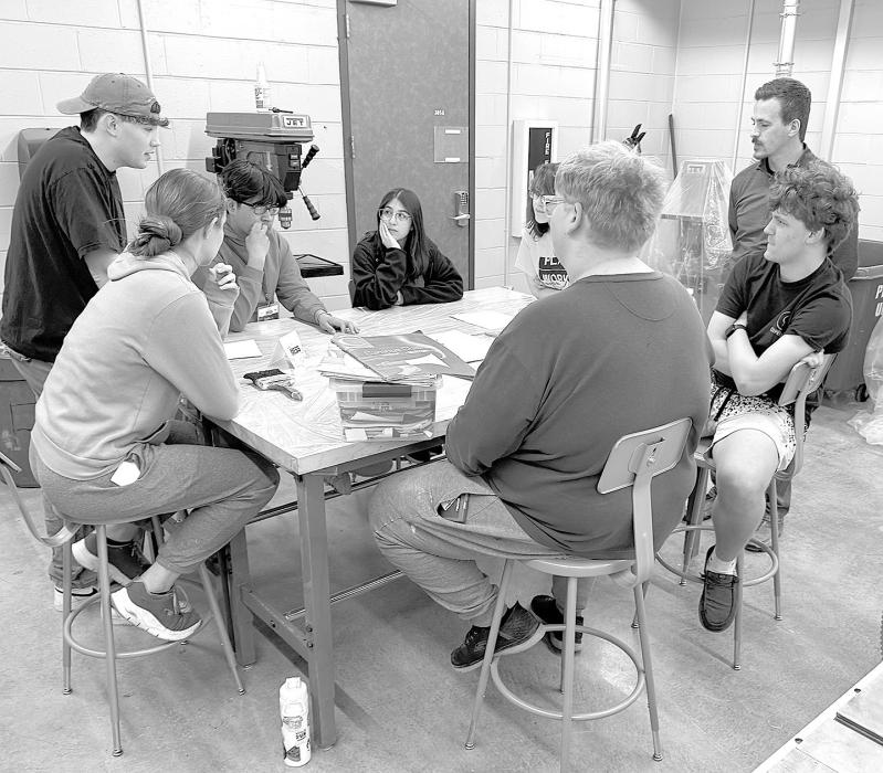 Annick Altamirano and Axel Luna collaborating with other students to create a painting.