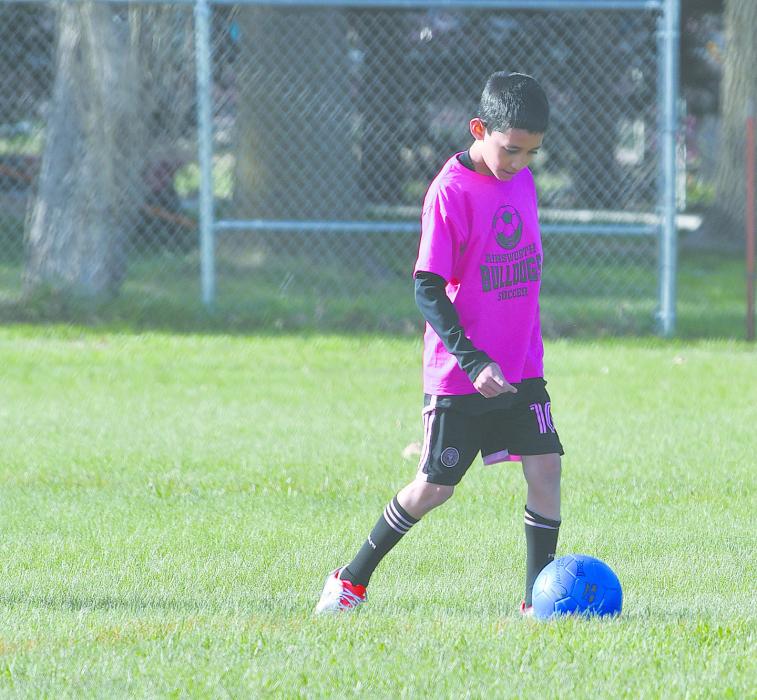 Kevin Gomez Nucamendi dribbles the soccer ball during the fifth and sixth grade game.