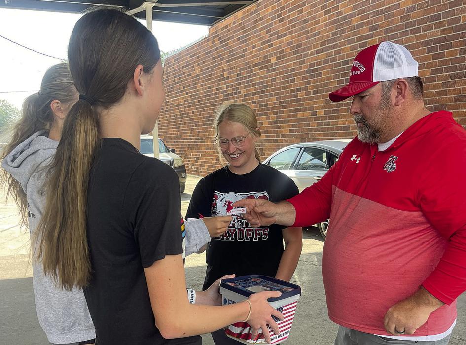 Sisson and Moody sell poppies to Clint Painter and Kerstyn Held at 1st Class Auto.
