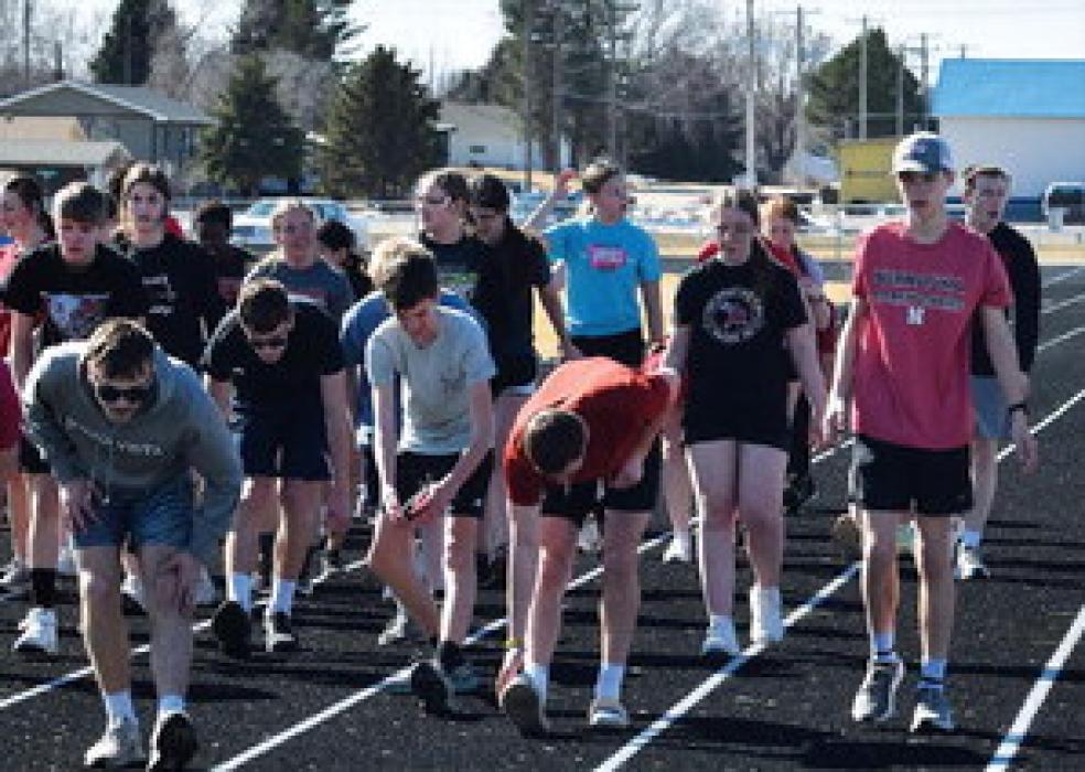 Bulldog track athletes warm up in preparation for practice after returning from spring break.