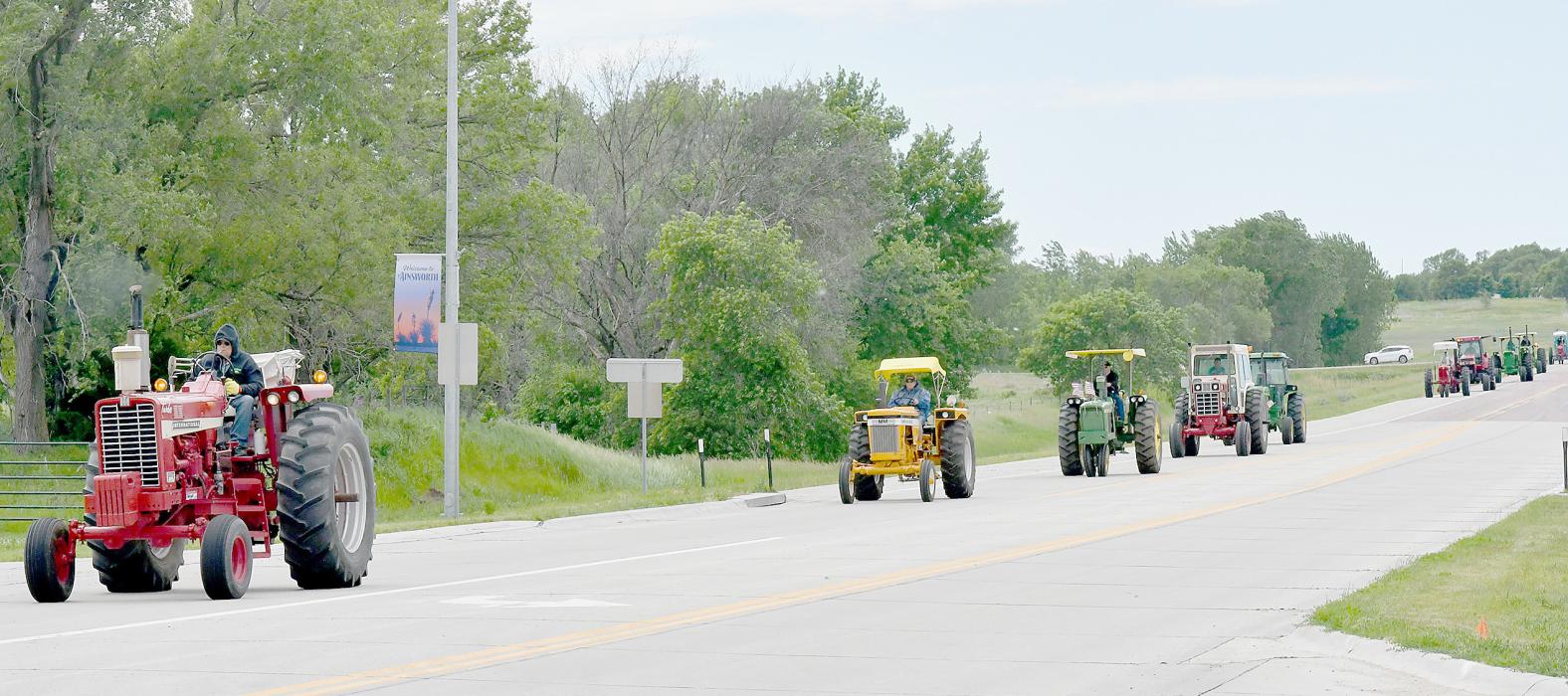 The Tractor Relay Across Nebraska rolled into the west side of Ainsworth around 3:00 p.m. on Tuesday, June 4th. Stretching across a mile, the tractor procession first headed to the Ainsworth Care Center, waving along the way to community onlookers.