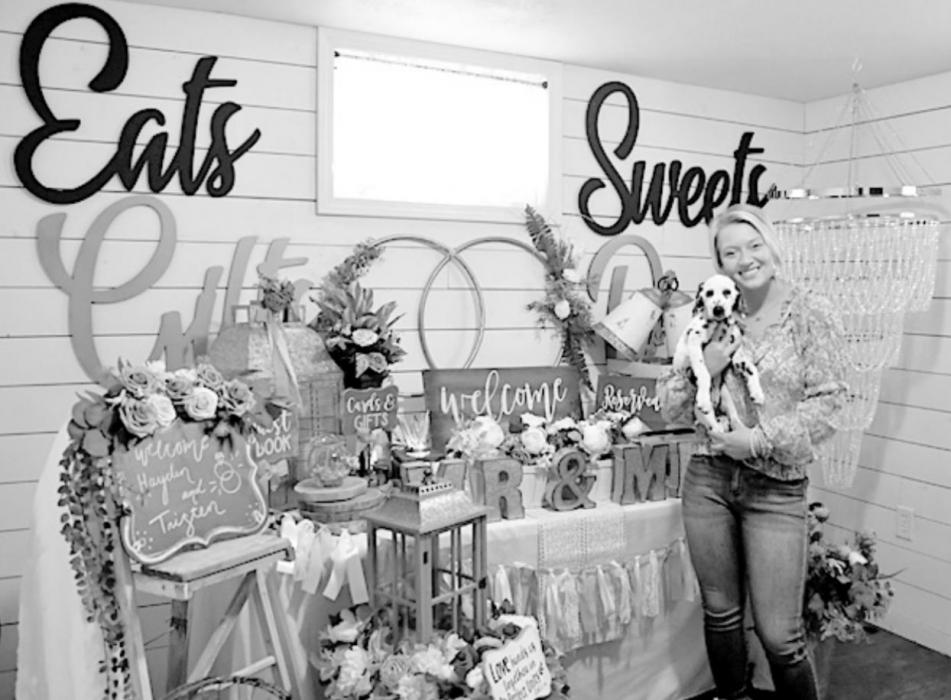 Macey Vonheeder, owner of I Do’s By Macey, is pictured with her puppy Anna in front of one of four varying styles of event decor displayed in her showroom.