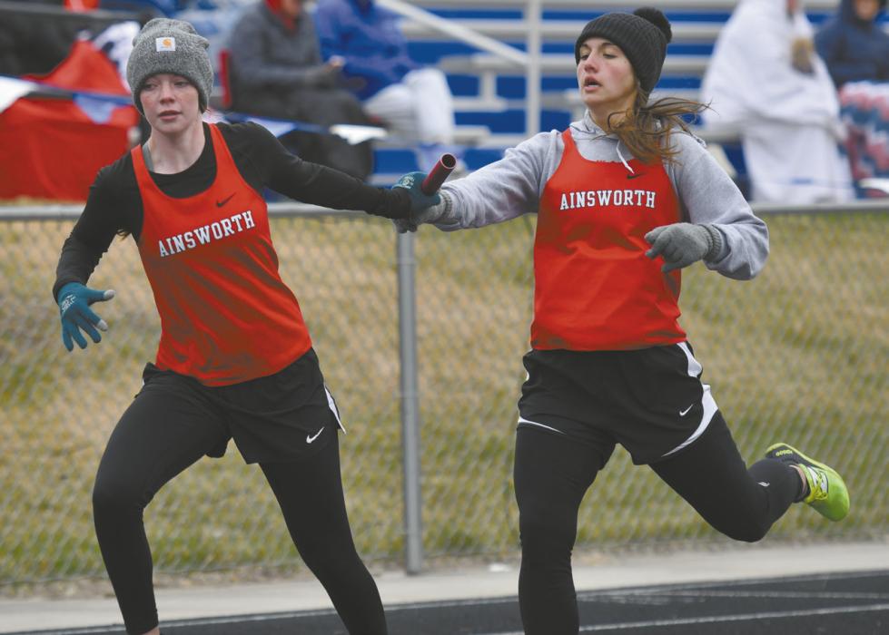 Junior Willa Flynn (right) hands the baton to senior Payton Moody (left) during the 4x400 meter relay. The team of Flynn, Reagan Moody, Payton Moody and Kiley Orton placed first at the meet.