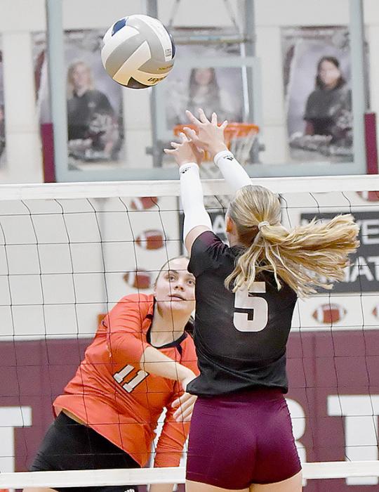 Karli Kral blows a kill shot past the attempted block of Lacey Paxton during the game between the Ainsworth Lady Bulldogs and Stuart Lady Broncos.