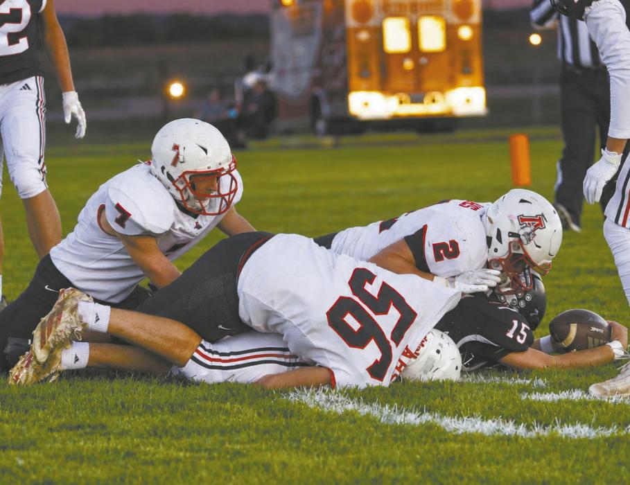 Ainsworth juniors Ben Clingman (7), Zaine Evans (2), and Kyle Fernandez (56) work to take down Creighton's Haiden Horstmann (15).