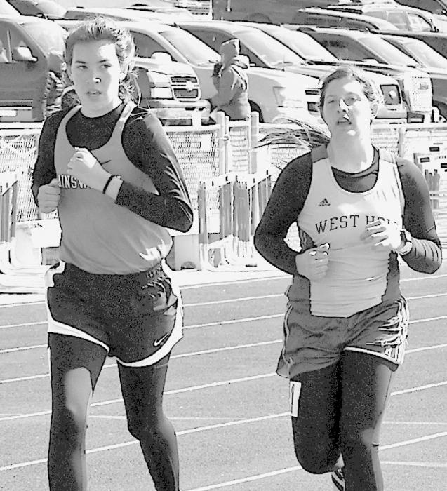 Katherine Kerrigan (left) of Ainsworth led most of the race in the 3200 Meter Run but was edged out for the win by Maddie Davis of West Holt (right) at the Sandhills Invite.