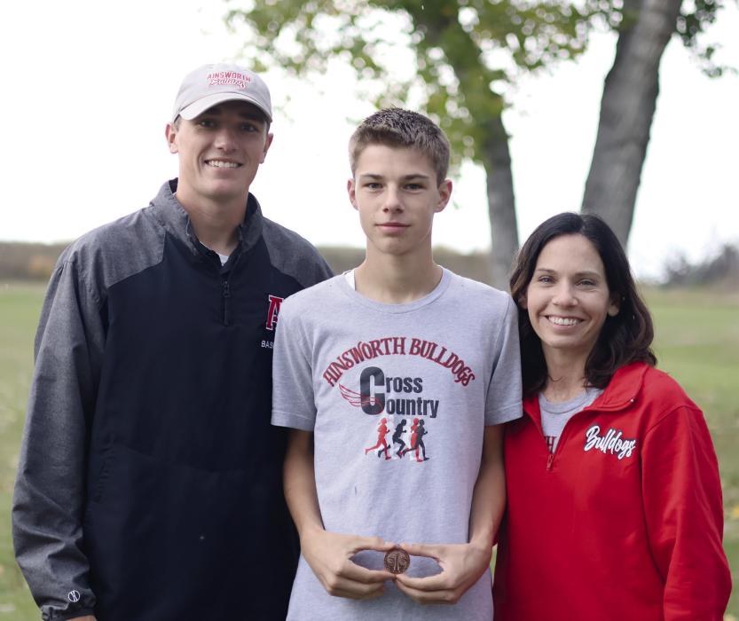 Holden Beel qualified for state cross country by placing ninth at the D-3 District Meet. He is pictured above with Coach Schlueter and Coach Winters.