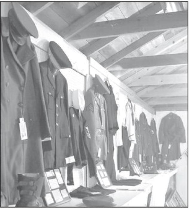 Several armed forces uniforms hung on display in the antiques division exhibit building.