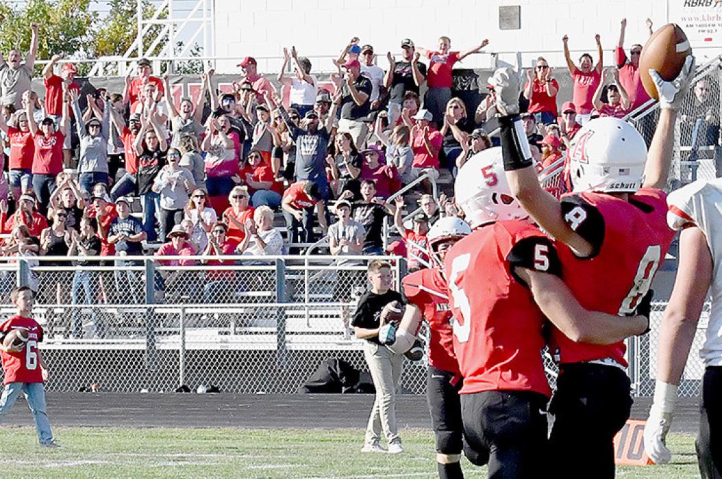 Traegan McNally, #8, celebrates with teammates while Bulldog fans go crazy in the stands following a 19 yard pass reception for the winning touchdown.