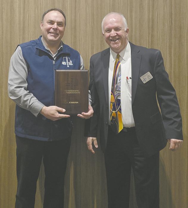 JackMoles, executivedirectoroftheNebraskaRuralCommunity Schools Association, awards Dale Hafer with his plaque.