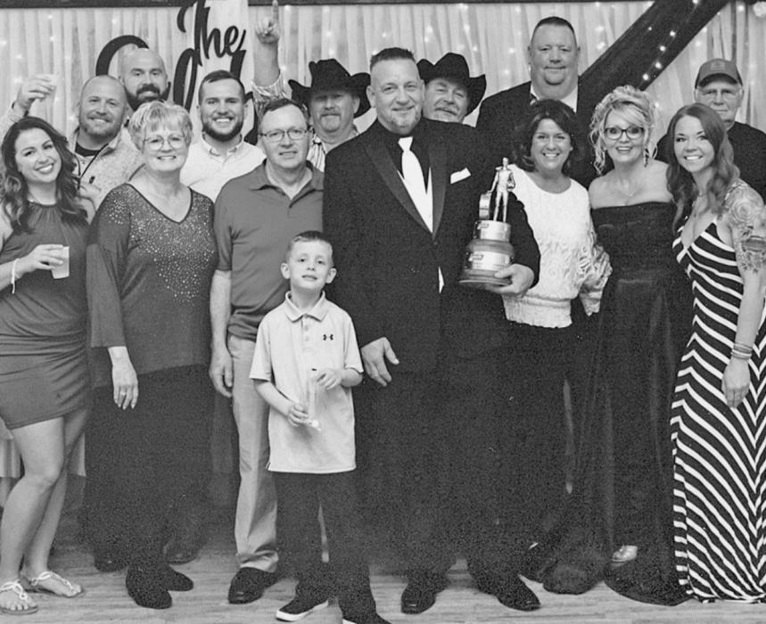 Mark VonHeeder (center), holding his Division Champion Wally trophy, is pictured with members of his “race family” at the March 2021 wedding of his daughter, Samantha Silsby. Samantha called her father up to the stage at her reception to be recognized and give a speech in lieu of the typical banquet held to honor the Top 10 racers in his Division, which was cancelled due to the pandemic.