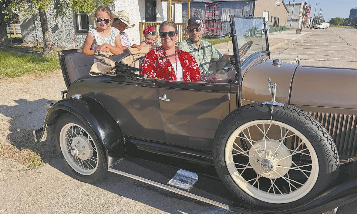 Jason, Margo, Jaide, Eli, and Nora Lehn enjoy Main Street Cruise Night in their 1928 Model A Ford Roadster.