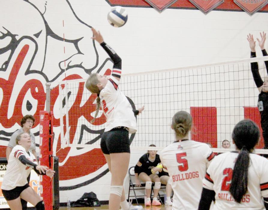 Jaylee Good goes up to spike the ball. Her Bulldog teammates (left to right) Lily Beel, Willa Flynn and Genessis Agin were ready to assist if the volleyball came back over.