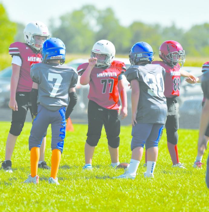 Callin Goochey directs his teammates as he prepares to snap the football to his quarterback during the fifth and sixth grade football game.