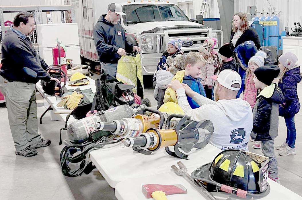 Firemen Justin Nickless, Scott Goodloe and Drake Fiala, explain how all the equipment on the table is used during fires and auto accidents.