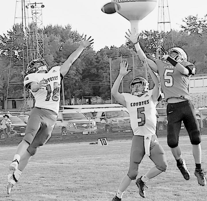 Owen Blumenstock goes up for a pass against two Coyote defenders.