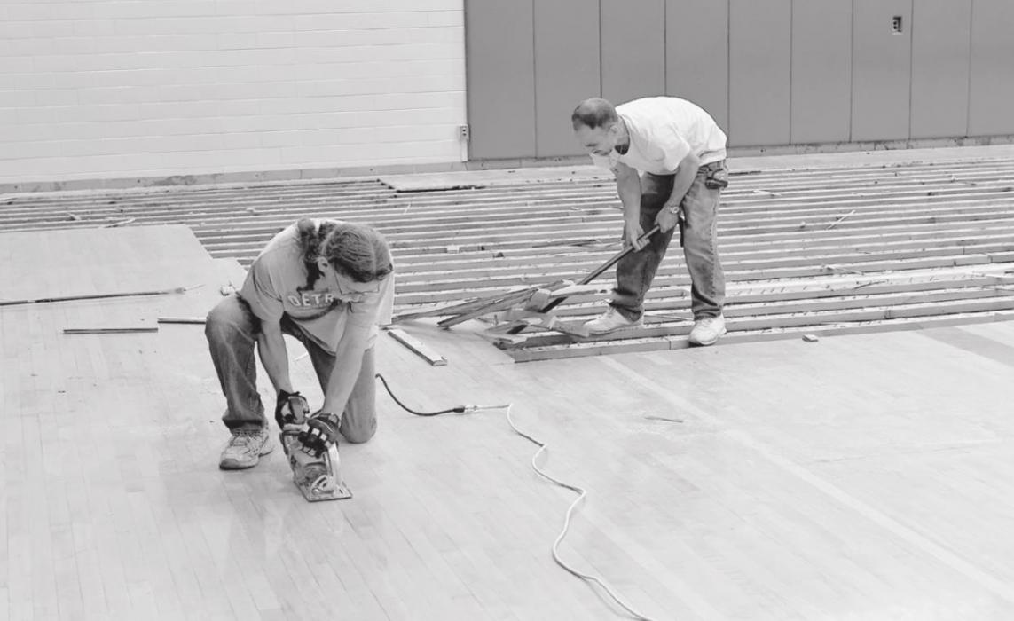 Workers remove the old McAndrew Gymnasium flooring on Wednesday, May 26th. The old floor was cut into sections and then pried up.
