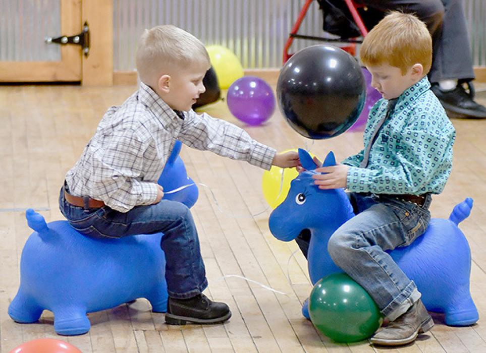 These two cowboys were having fun riding the blue bouncy horses. Anyone who rode them seemed to have a great time.