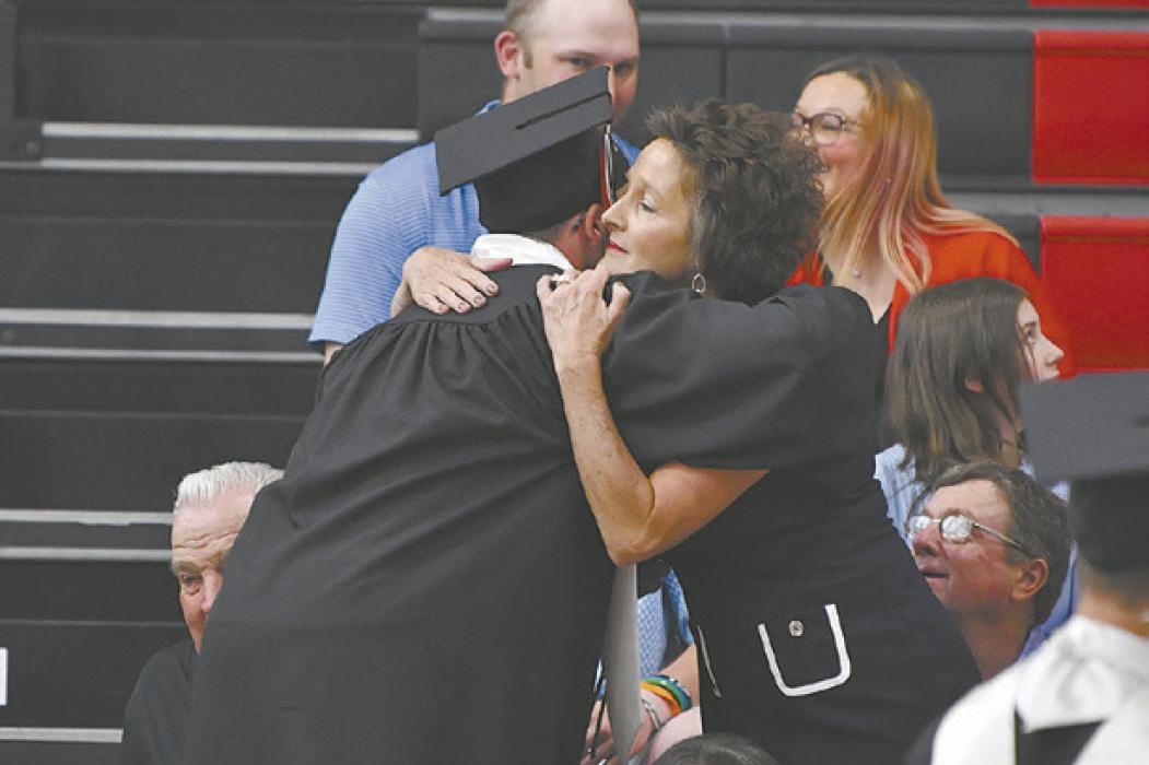 Ryan Salzman delivers a white rose to his mother Amy as the class song “Daylight” by Maroon 5 plays.