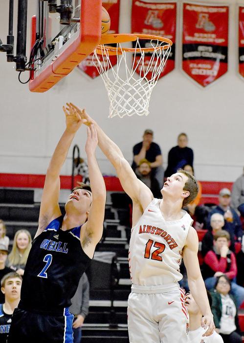 Senior Logan Schroedl attempts to block O’Neill’s Porter Mathews shot from below the basket.