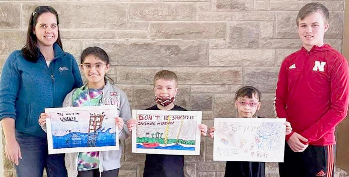 Third-grade poster artists of Brown County entered the 2022 Nebraska Severe Weather Awareness contest in February, and the three showing off their posters above qualified for the state contest. Pictured are (Left to Right): Brown/Rock Emergency Management Agency (BREMA) Director Traci Booth, Ursula Morales, Blake Hansmeyer, Renata Kislev and BREMA C.O.E. student and AHS senior Cash Reynolds.